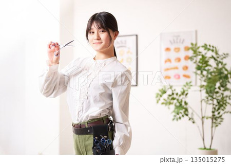 笑顔で視線を向けるヘアスタイリスト 135015275