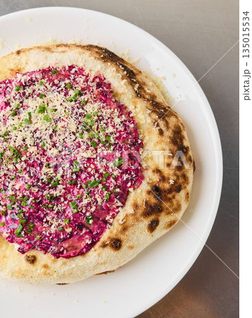 Macro image showcasing herbcrusted beet pizza with sesame seeds and parsley 135015534