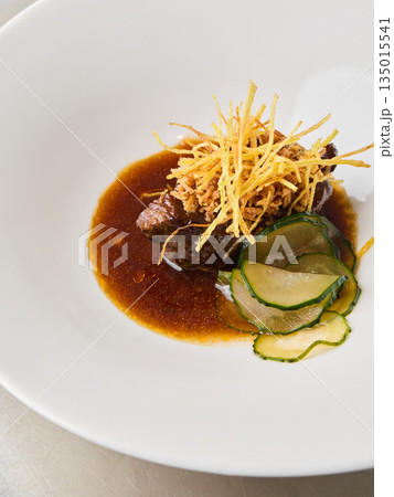 Soothingly cooked beef served alongside crispy accompaniments and zucchini Soothingly cooked beef served alongside crispy accompaniments and zucchini 135015541