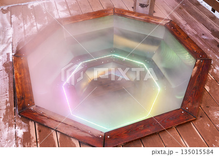 Sunset glow surrounds steaming cedar basin on snowy deck Sunset glow surrounds steaming cedar basin on snowy deck 135015584