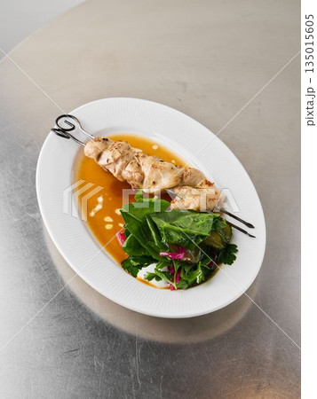 Upscale casual dining with stylish chicken skewers and vibrant vegetables 135015605