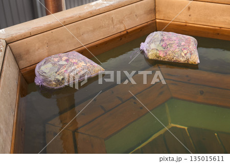 Clean And Ecofriendly Bath Sachets Gently Floating Beside Warm Wooden Edges And Delicate Petals 135015611
