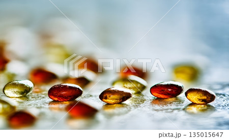 Shiny amber and red gelatin softgel capsules containing nutritional supplement for health wellness dietary needs everyday use benefits. AI Generated 135015647