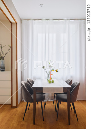 Charming breakfast nook featuring soft curtains and wooden accents Charming breakfast nook featuring soft curtains and wooden accents 135015710