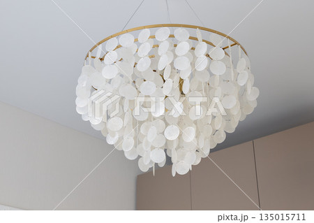 Stylish capiz shell chandelier creating cozy ambient lighting indoors Stylish capiz shell chandelier creating cozy ambient lighting indoors 135015711