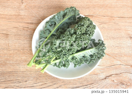fresh green Curly Kale vegetable salad with drop of water arranging on plate fresh green Curly Kale vegetable salad with drop of water arranging on plate 135015941