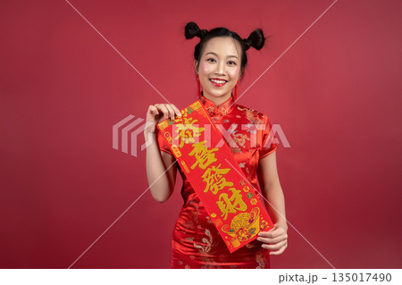 Portrait of beautiful woman celebrating Lunar New Year with festive banner Portrait of beautiful woman celebrating Lunar New Year with festive banner 135017490