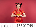 Beautiful smiling girl celebrating Lunar New Year with symbol of wealth and luck Beautiful smiling girl celebrating Lunar New Year with symbol of wealth and luck 135017491