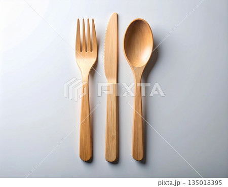 Sustainable packaging. Set of eco-friendly bamboo cutlery: wooden spoon, fork and knife on a white background. Sustainable packaging. Set of eco-friendly bamboo cutlery: wooden spoon, fork and knife on a white background. 135018395