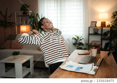 Young adult woman stretching at home office desk relaxing Young adult woman stretching at home office desk relaxing 135018475