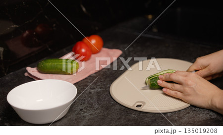 Chef slicing cucumber on cutting board Chef slicing cucumber on cutting board 135019208