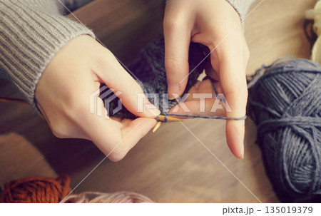 棒針で毛糸を編んでいる手元の写真　編み物　ハンドメイド　ケーブル編み　アラン模様　趣味 135019379