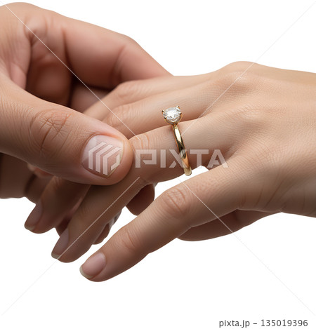 Romantic moment as a man's hand places a diamond engagement ring on a woman's finger, symbolizing marriage proposals and commitment 135019396