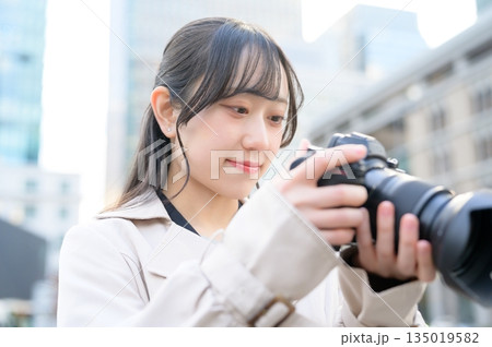 オフィス街でカメラを持つ日本人女性 135019582