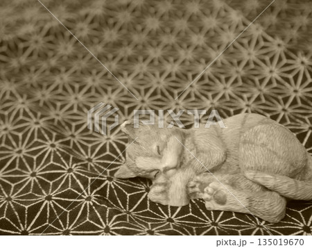 気持ちよさそうに眠るネコの置物 135019670