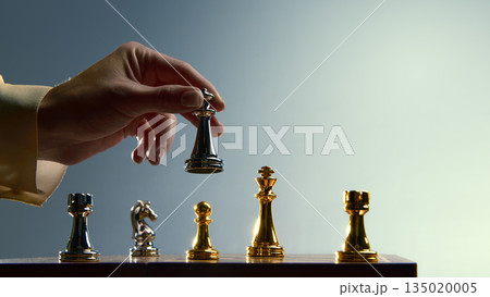 Hand lifting gold queen to signal priority move. Hand lifting gold queen to signal priority move. 135020005