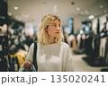 Beautiful woman shopping in supermarket and deciding what to buy, generated AI 135020241
