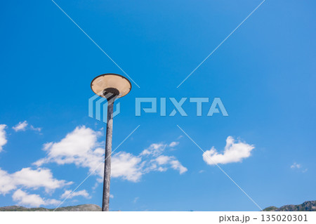 Street lamp against a clear blue sky with scattered clouds. Copy space and empty place for text Street lamp against a clear blue sky with scattered clouds. Copy space and empty place for text 135020301