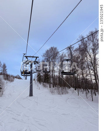 A chairlift for two at the ski resort. Vertical photo A chairlift for two at the ski resort. Vertical photo 135021945