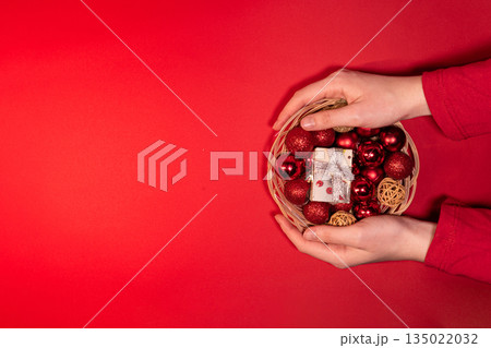 Christmas Basket with Red and Gold Decorations on Red Background 135022032