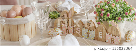 Festive Easter table setting with Easter bunny made from napkin. Easter celebration concept 135022364