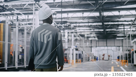 Industrial Supervisor Monitoring Automated Manufacturing Process on Wide Factory Floor Industrial Supervisor Monitoring Automated Manufacturing Process on Wide Factory Floor 135022403