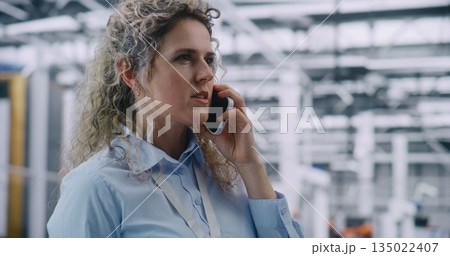 Female Engineer Talking on Mobile Phone With Serious Expression Female Engineer Talking on Mobile Phone With Serious Expression 135022407