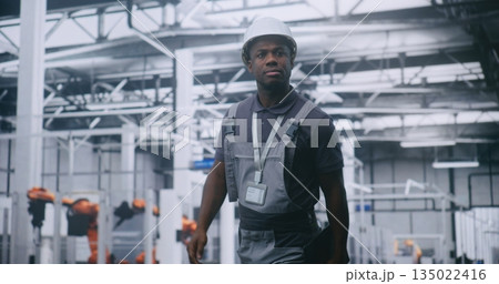 Factory Supervisor Walking Across High Tech Manufacturing Facility Factory Supervisor Walking Across High Tech Manufacturing Facility 135022416