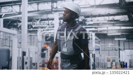 Factory Supervisor Walking Across High Tech Manufacturing Facility 135022421