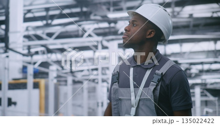 Engineer Walking Through Factory Floor and Inspecting Automated Production Lines and Robotic Equipment 135022422