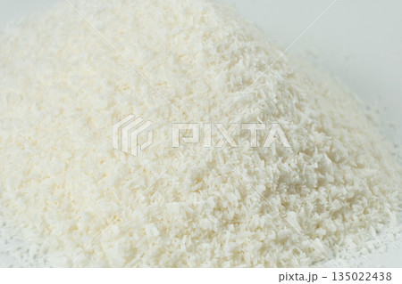 Pile of coconut flakes on white background macro Pile of coconut flakes on white background macro 135022438