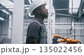Focused Factory Engineer Provides Professional Monitoring Industrial Systems in Safety Hard Hat 135022456