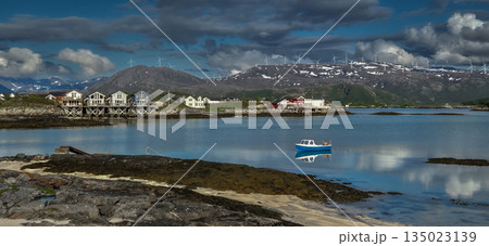 Coastal Landscape With Calm Fjord, Snowy Mountains With Wind Turbines And Cottages On Sommaroy Island  In Norway 135023139