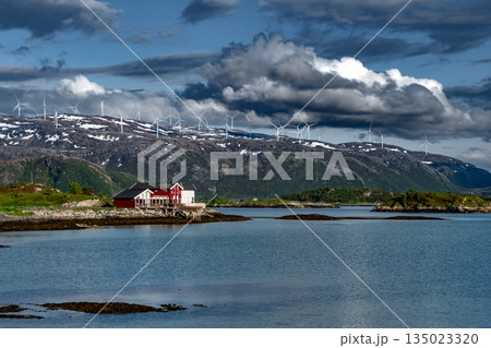 Coastal Landscape With Calm Fjord, Snowy Mountains With Wind Turbines And Cottages On Sommaroy Island  In Norway 135023320