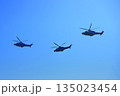 Helicopters fly under a blue sky. Tourist helicopter flights. Cargo delivery by air 135023454
