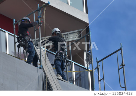 マンション新築工事　仮設足場の解体作業風景 135024418