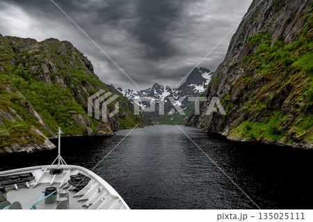 Cruise Ship Approaches High Bridge Over Calm Fjord Near Stokmarknes At The Lofoten In Norway Cruise Ship Approaches High Bridge Over Calm Fjord Near Stokmarknes At The Lofoten In Norway 135025111
