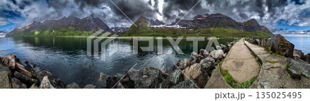 Calm Fjord With Red Huts In Front Of Snowy Mountains On Senja Island In Norway 135025495