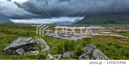Cloudy Mountains And Calm Fjord With Bridge On Lofoten Islands In Norway 135025498
