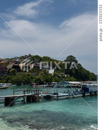 calm waters with boats and distant island, peaceful maritime environment with seaplane in distance, Nusa Penida, Indonesia 135025552
