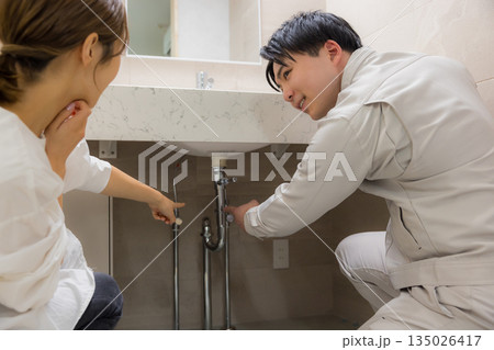 作業着を着た男性と修理を依頼する女性 135026417
