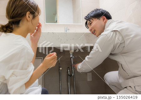 作業着を着た男性と修理を依頼する女性 135026419