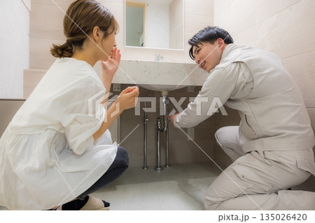 作業着を着た男性と修理を依頼する女性 135026420