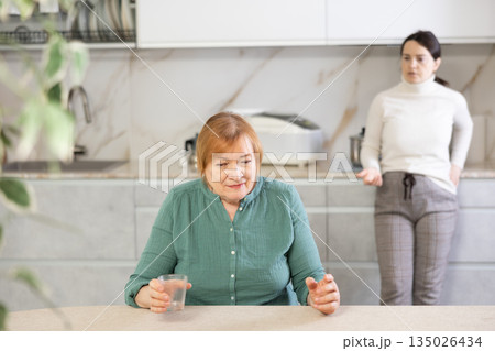 Adult woman and young woman during quarrel in kitchen Adult woman and young woman during quarrel in kitchen 135026434