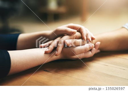 Holding hands, comfort and support of friends, care and empathy together on table in home mockup. Kindness, love and women hold hand for hope, trust or prayer, solidarity or compassion, help or unity 135026597
