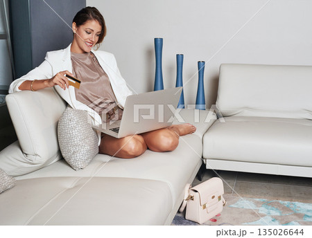 Laptop, credit card and woman on sofa online shopping, ecommerce and fintech application, loan or finance at home. Happy rich person typing, banking or website on computer, digital payment for wealth Laptop, credit card and woman on sofa online shopping, ecommerce and fintech application, loan or finance at home. Happy rich person typing, banking or website on computer, digital payment for wealth 135026644