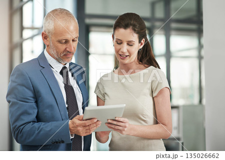 Business people, tablet and communication on a web management project with tech. Staff, corporate team and mature CEO with woman worker planning a internet UI strategy in a office with a conversation 135026662