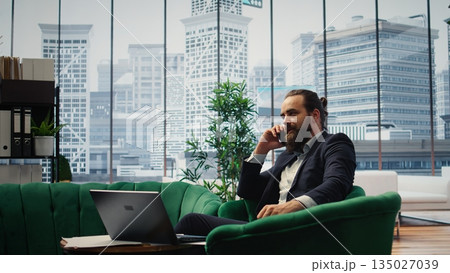 Director engaging in an executive phone call discussion with a financial broker, sharing insight on market forecasts and investment strategy, demonstrating his eye for business ideas. Camera A. 135027039