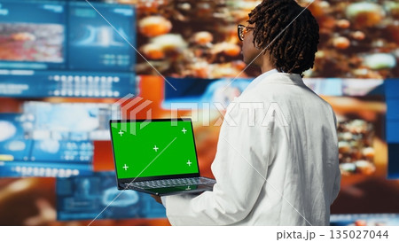 Isolated screen laptop used by scientist to review medical scans. Woman in front of digital health dashboards backdrop analyzing human anatomy with chroma key notebook device, camera B Isolated screen laptop used by scientist to review medical scans. Woman in front of digital health dashboards backdrop analyzing human anatomy with chroma key notebook device, camera B 135027044