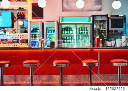 Retro, vintage and stools with interior in a diner, restaurant or cafeteria with funky decor. Trendy, old school and chairs by a counter or bar in groovy, vibrant and stylish old fashioned empty cafe Retro, vintage and stools with interior in a diner, restaurant or cafeteria with funky decor. Trendy, old school and chairs by a counter or bar in groovy, vibrant and stylish old fashioned empty cafe 135027226